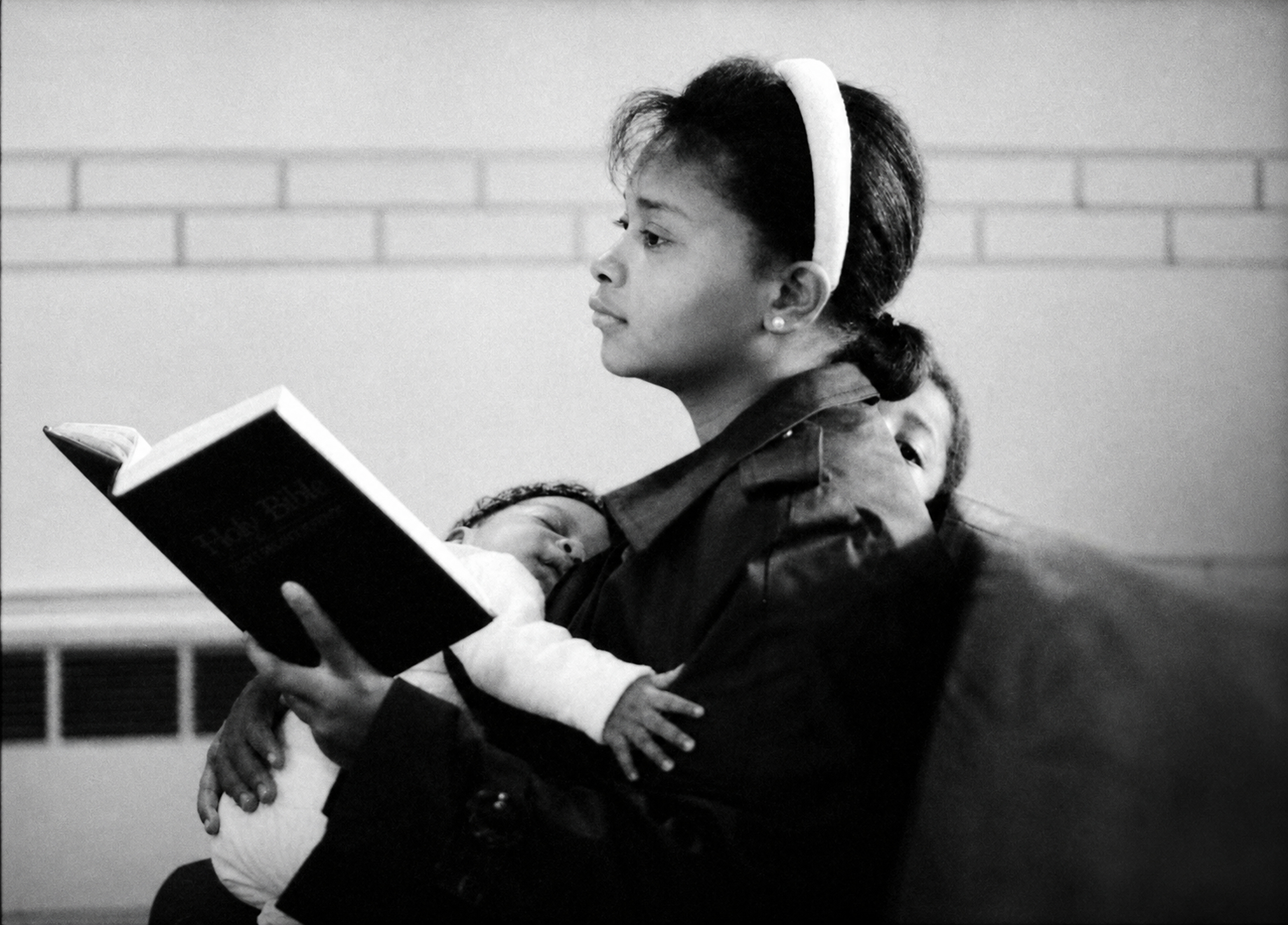 A mother holding two children while listening to a sermon at Roseland Christian Ministry Center in Chicago, 1989