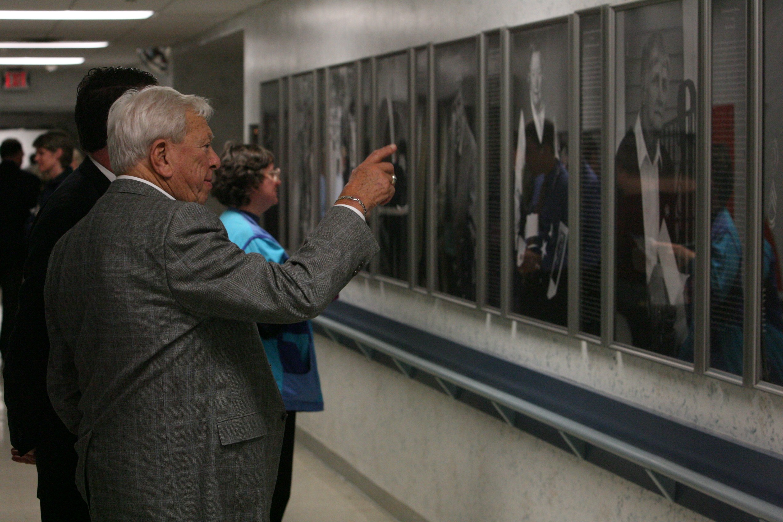 A veteran studying the installed Michigan Veterans of Five Wars portrait and story panels